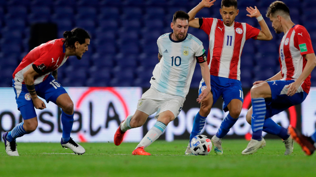 Messi dribbling past Paraguay players