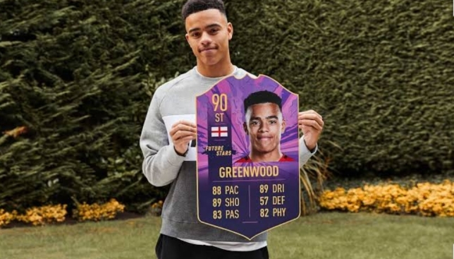 Mason Greenwood holding his FIFA 21 card