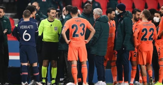 PSG and Istanbul Basaksehir players surround the match officials
