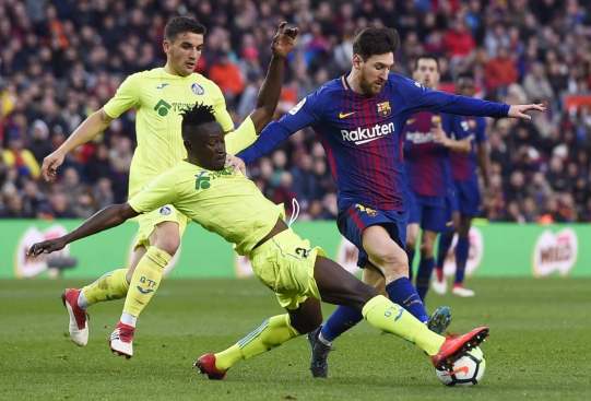 Djene Dakonam tackling Lionel Messi